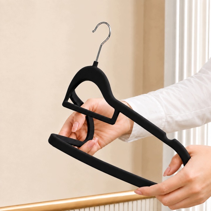 Čierne velúrové vešiaky Ogivo, sada 50 kusov, šírka 44,5 cm. Velúrové vešiaky na oblečenie zjednotia uloženie košieľ, blúzok, šiat aj nohavíc. Päťdesiat čiernych kusov pripraví samostatné miesta pre viac odevov a spríjemní pohľad do usporiadaného šatníka.